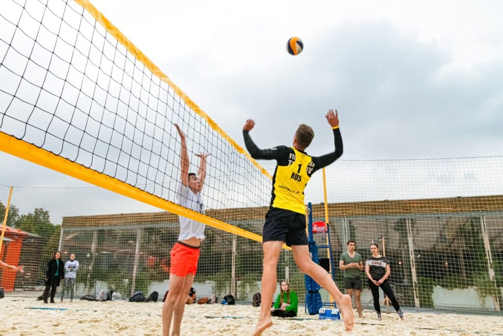 spiking ball on beach volleyball court